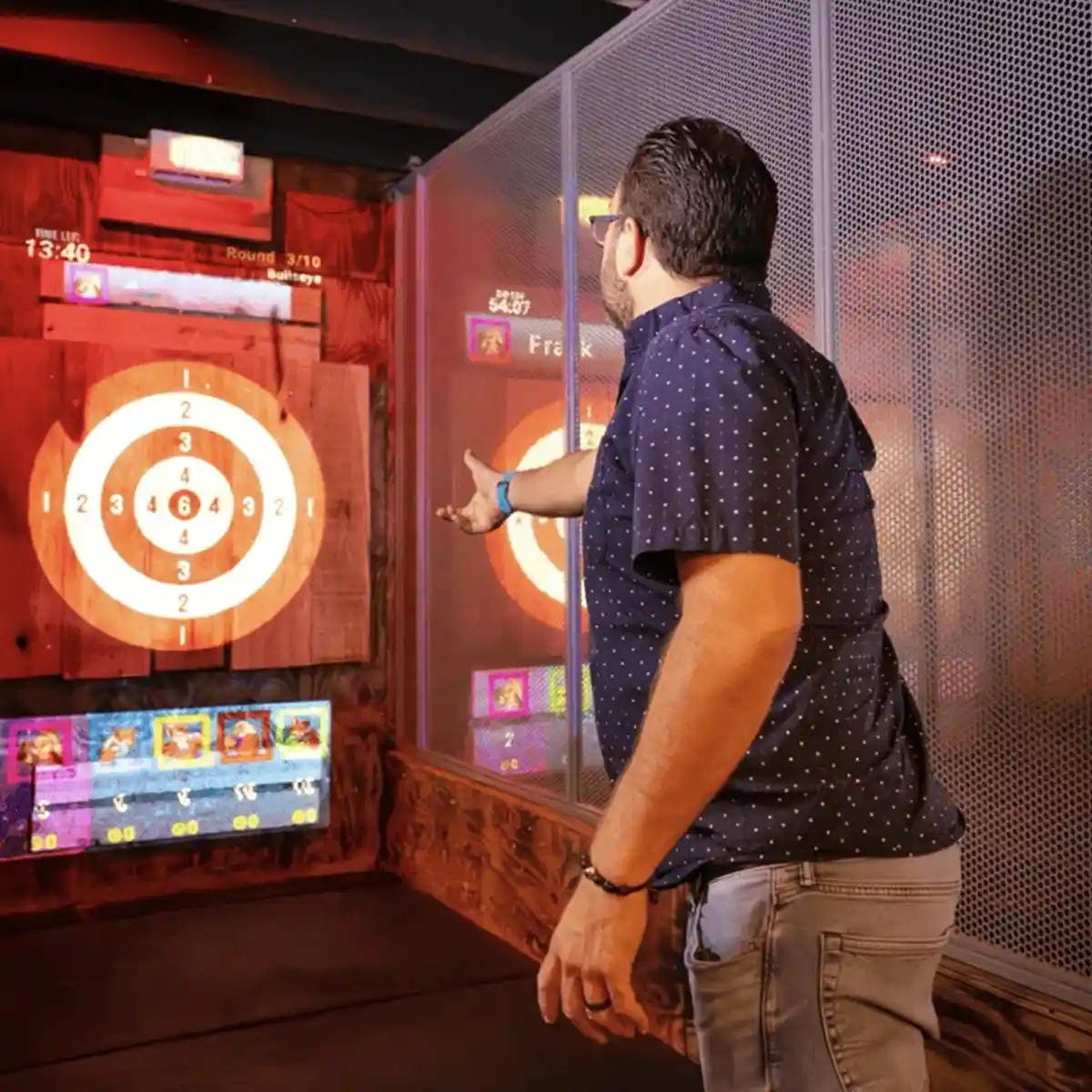 Man throwing axes at a digital target in an indoor axe throwing attraction near Zion in Hurricane Utah