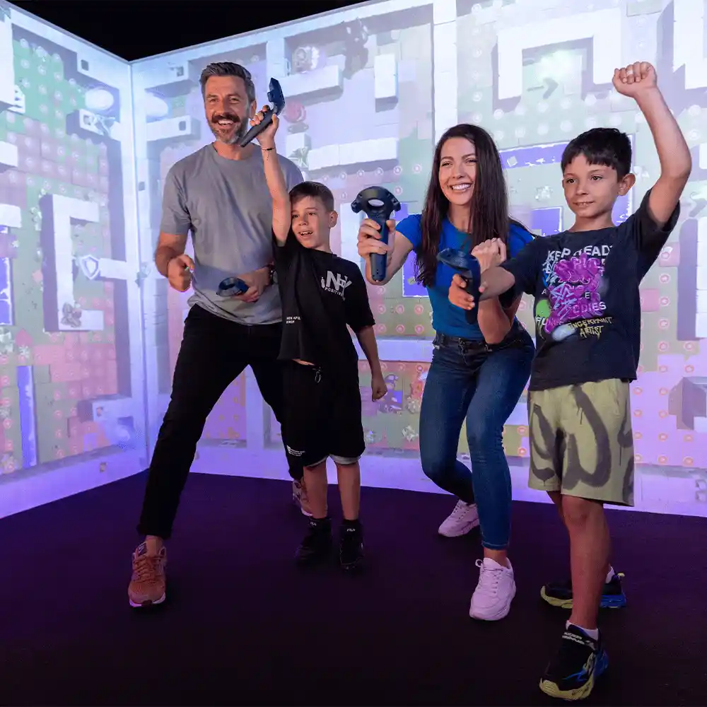 Family celebrating win inside QBIX interactive VR game room in Hurricane Utah during multiplayer challenge