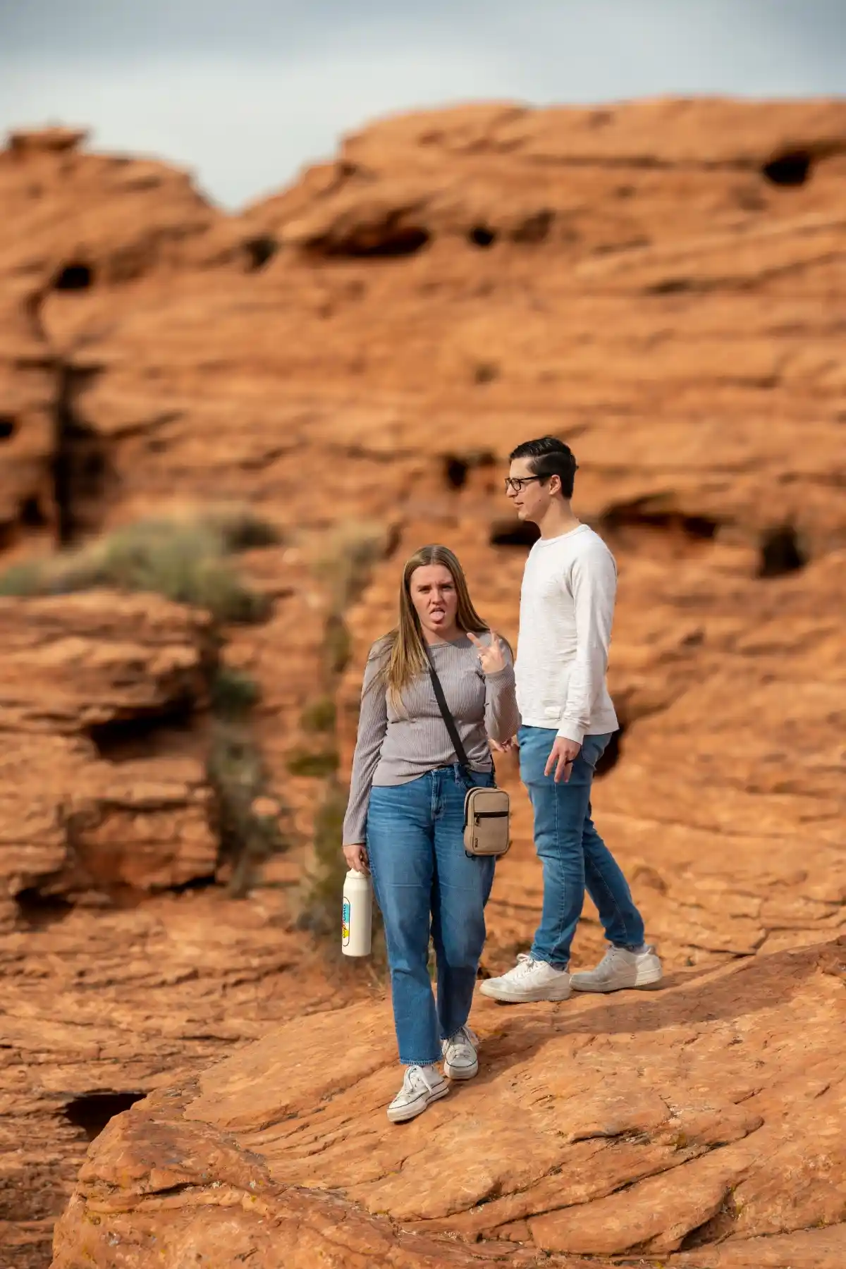 st-george-utah-hiking-group-decision-fatigue-red-rock-desert-exploring Couple exploring red rock landscape near St George Utah showing group decision fatigue after hiking and looking for things to do nearby